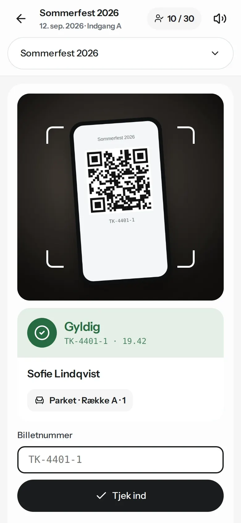 Check-in på mobilen: kameraet er åbent som scanner, og billetten er godkendt som gyldig med gæstens navn og plads.